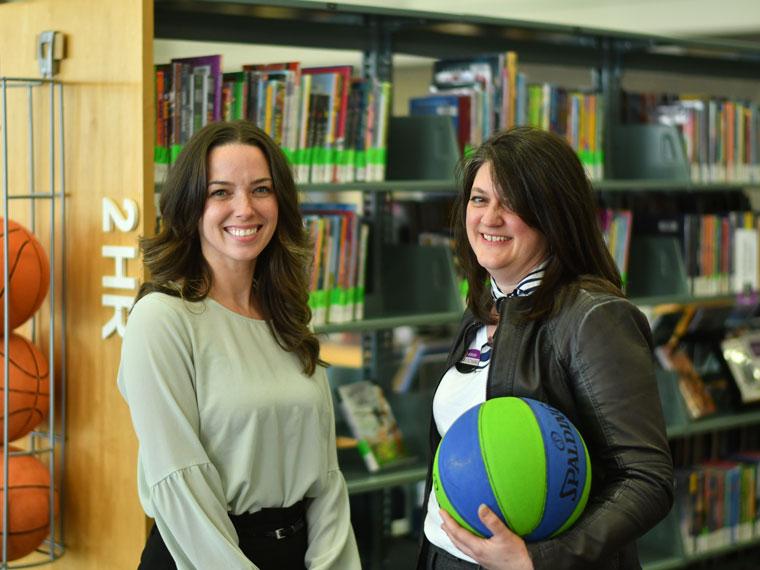 Clemens Mill staff members Kimberley (left) and Kathleen (right) holding a basketball.