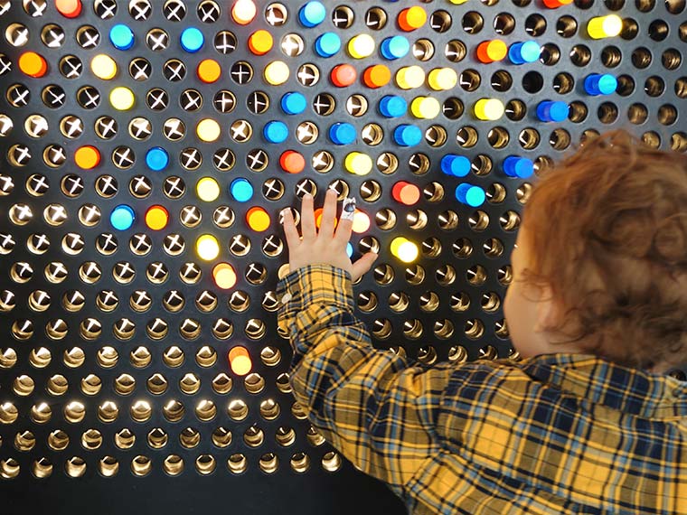 child using litebrite wall