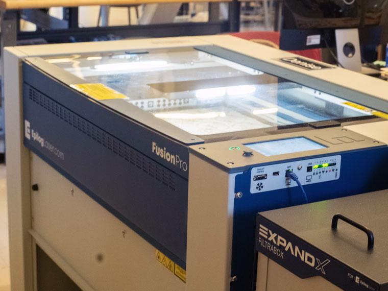Epilog Fusion Pro Laser Cutter lit up inside.