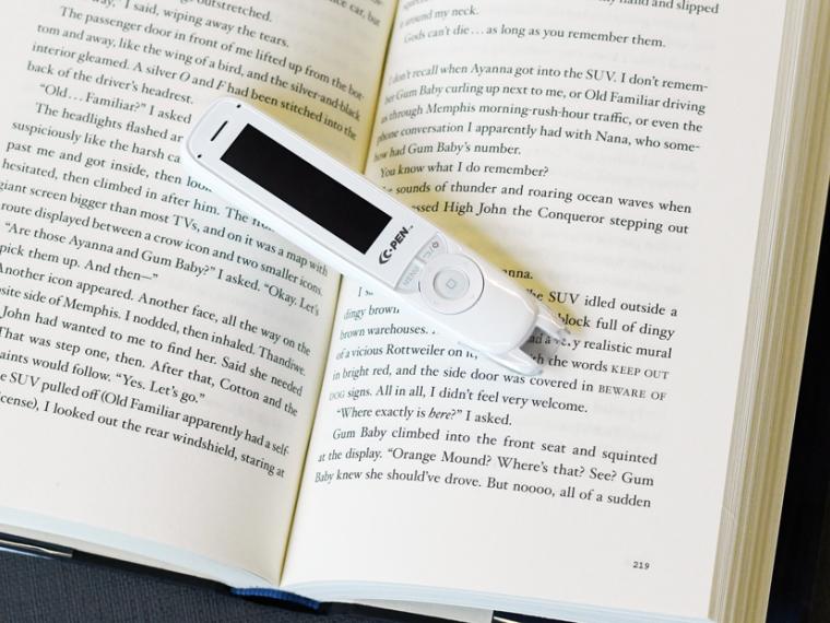 C-Pen ReaderPen placed in the centre of an open book.
