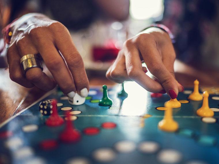Close up of two hands playing a board game.