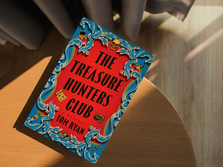 Book copy of the Treasure Hunters Club on a wood table with shadows on floor.