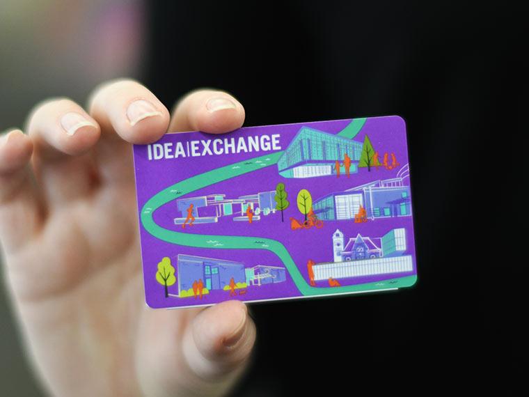 Hand holding Idea Exchange membership card.