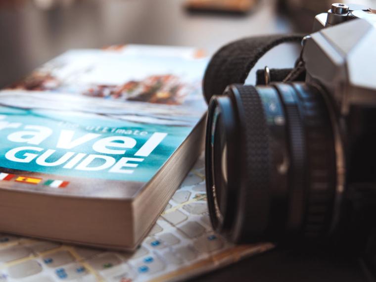 Travel guide and camera on a table in a coffee shop.