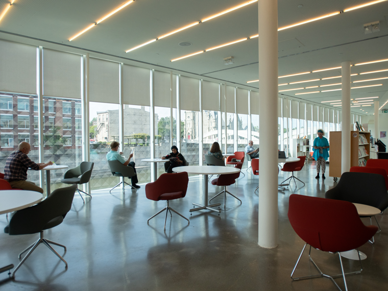 People sitting at tables in the Old Post Office Riverview Reading Room.