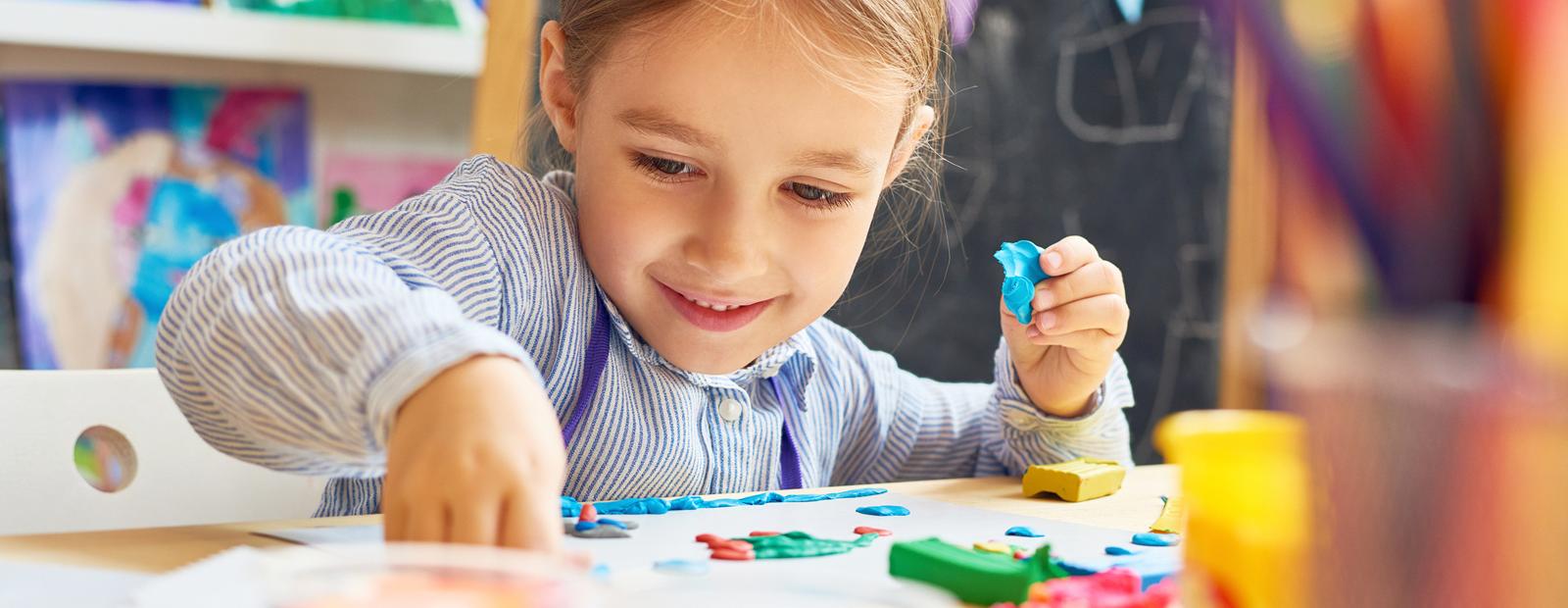 A child sitting at a table crafting.