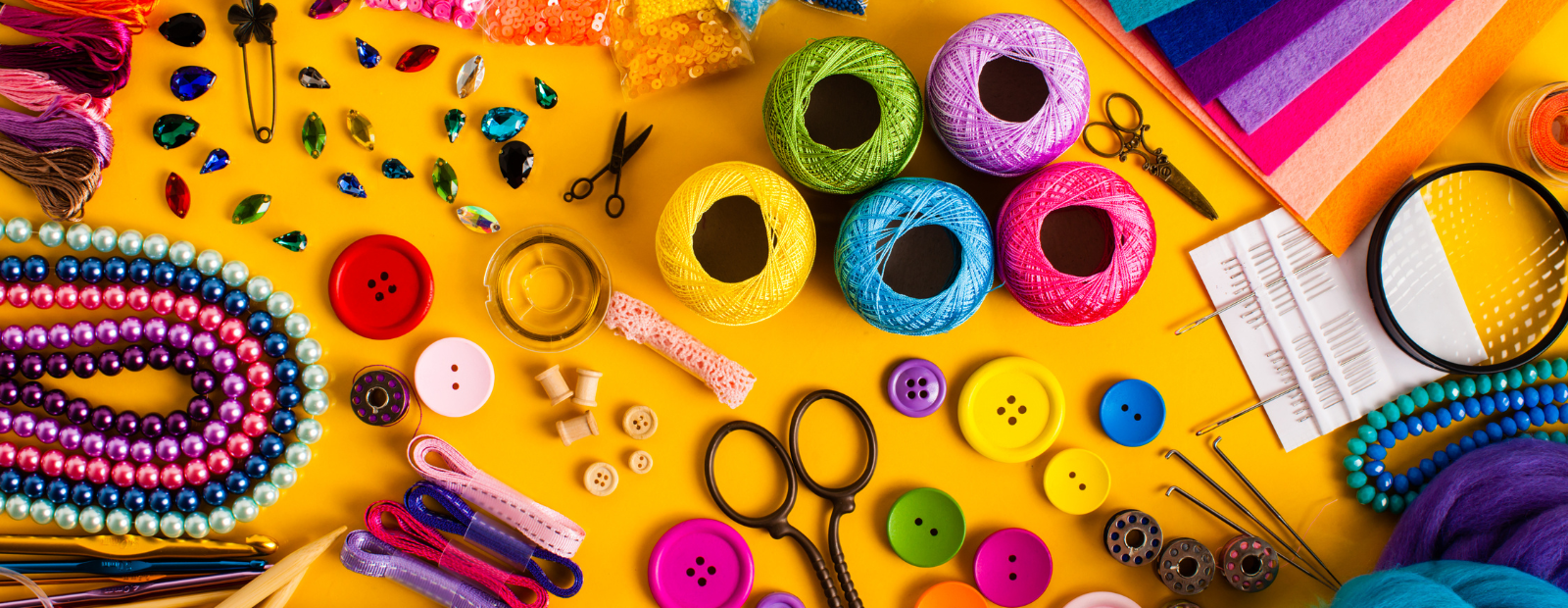 A photograph showing colourful craft supplies on a yellow background.