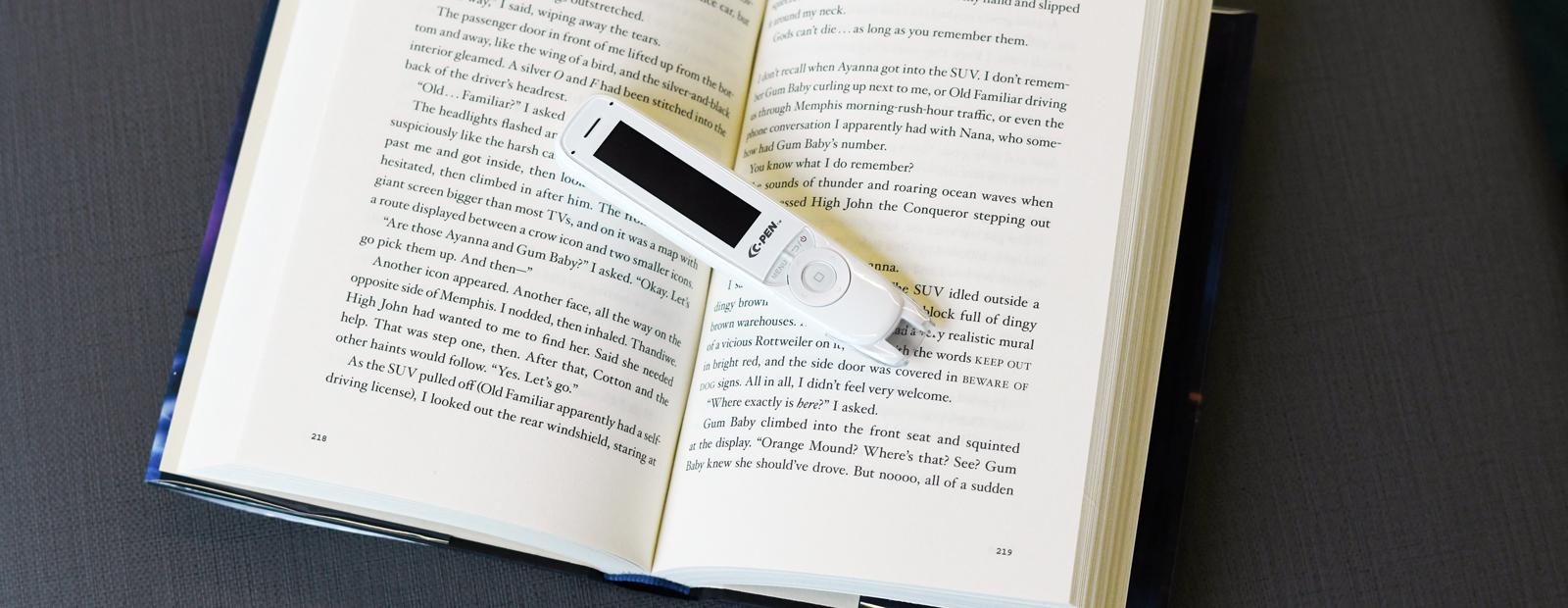 C-Pen ReaderPen placed in the centre of an open book.