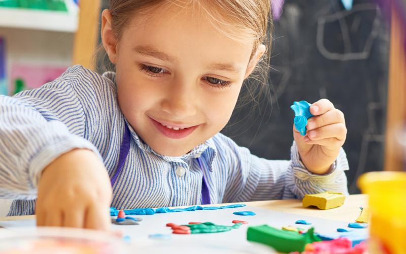 A child sitting at a table crafting.